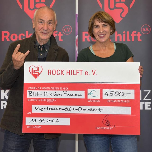 auf dem Bild sind ein Mann und eine Frau zu sehen welche einen Spendenscheck in die Kamera halten 