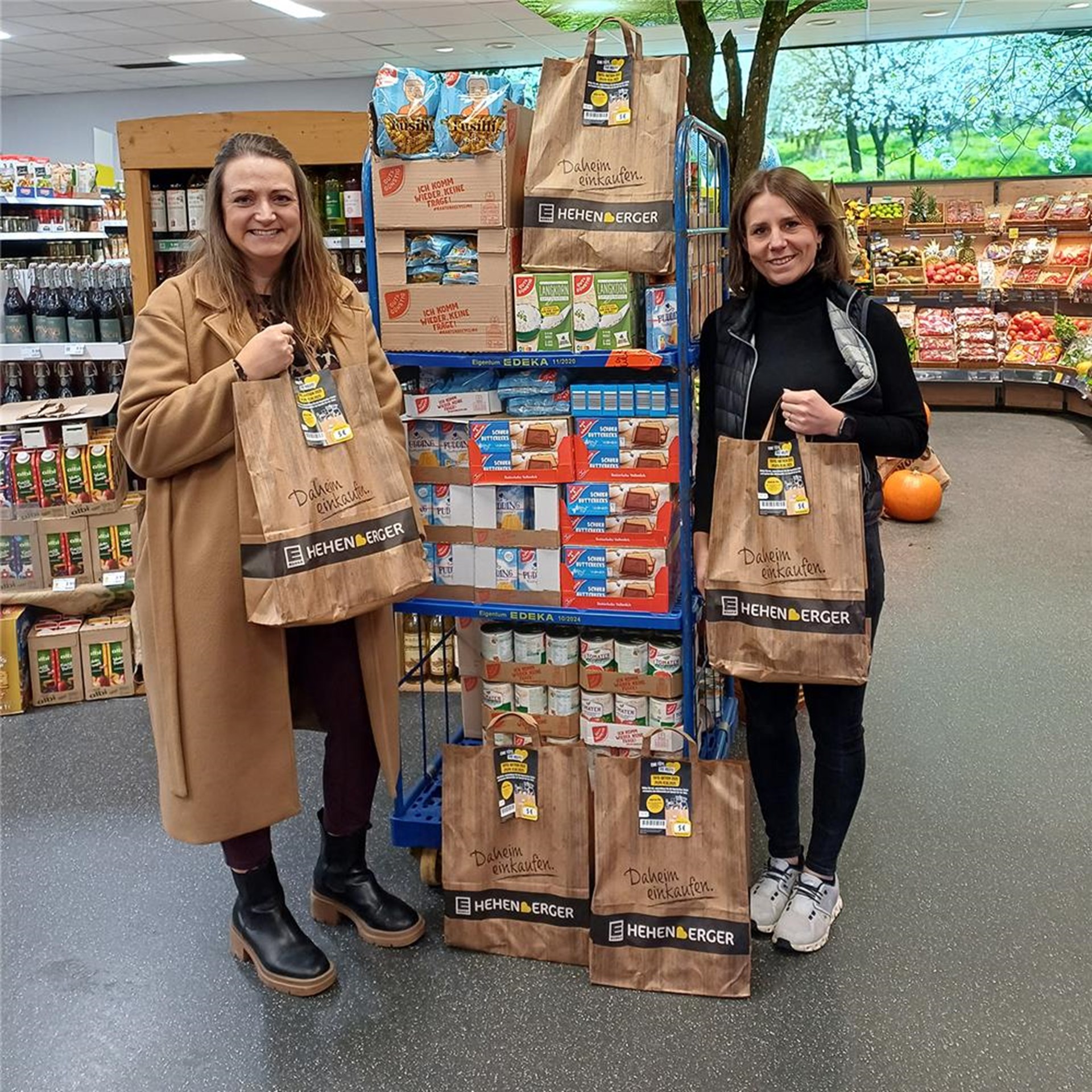 Zwei Personen stehen inmitten zahlreicher Produkte in den Verkaufsräumen eines Edekas.