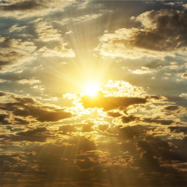auf dem Bild ist ein Sonnenaufgang zu sehen mit Wolken und Meer